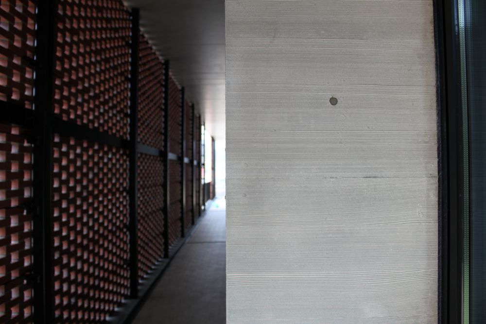 モールドスター仕上げによる打ち放しコンクリート壁面の施工事例。Exposed concrete wall with mold star formwork pattern finish, featuring precise architectural surface restoration in Japan.